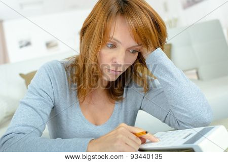 Lady using calculator, stressed