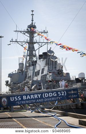 STATEN ISLAND, NY - MAY 24 2015: Two female sailors leave the USS Barry (DDG 52) via the metal gangplank with the ships banner hanging from it while moored at Sullivans Pier during Fleet Week NY 2015.
