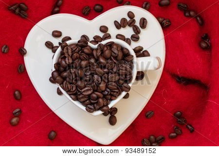 Heart Shaped Cup With Coffee Beans On Red