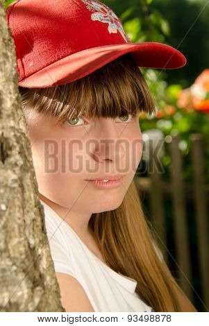 The girl the teenager laughs, standing at a birch, in the village