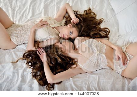 Female Portrait Of Cute Twins In Underwear Indoors. Close-up Beautiful Sexy Model Girls In Elegant P