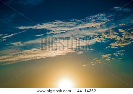 The sun produces iridescent clouds at sunset.