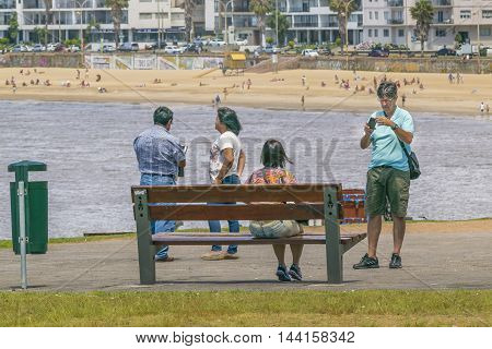 MONTEVIDEO, URUGUAY, DECEMBER - 2015 - Group of people at park in front of beach in Montevideo Uruguay