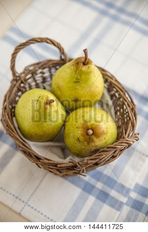 Pears with autumn leaves on wooden background