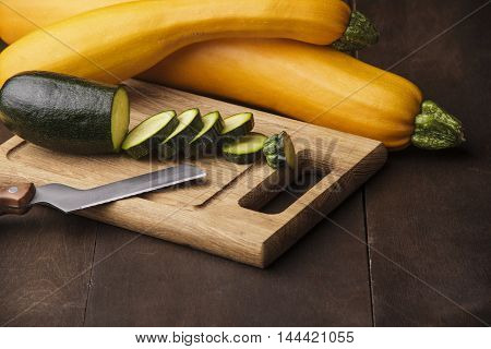 A fresh sliced zucchini on wooden kitchen desk with knife.wooden background.free space