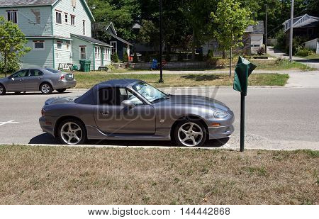 PETOSKEY, MICHIGAN / UNITED STATES - AUGUST 5, 2016: A small Mazda convertible sports car is parked near downtown Petoskey.