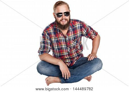 young bearded lumberjack sitting in sunglasses, studio isolated