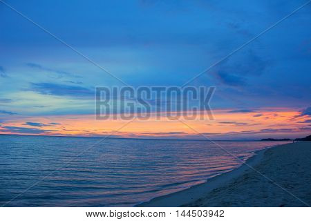 Sunrise morning time before. Colorful sky and water in lake reflected. Select focus with shallow depth of field Soft focus noise and grain due long exposure.