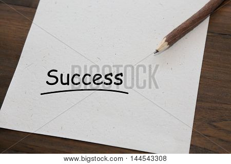 background of pencil with word success on old wood table