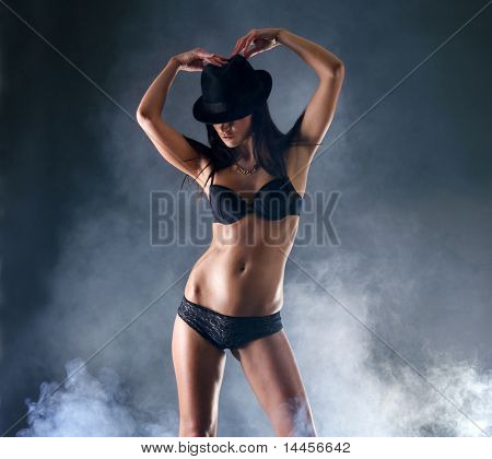 Mujer sexy en lencería erótica sobre fondo oscuro con humo