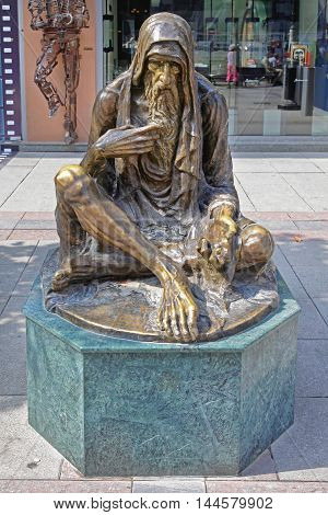 SKOPJE MACEDONIA - SEPTEMBER 17: Beggar Sculpture in Skopje on SEPTEMBER 17 2012. Poor Old Man Bronze Statue in Downtown Skopje Macedonia.