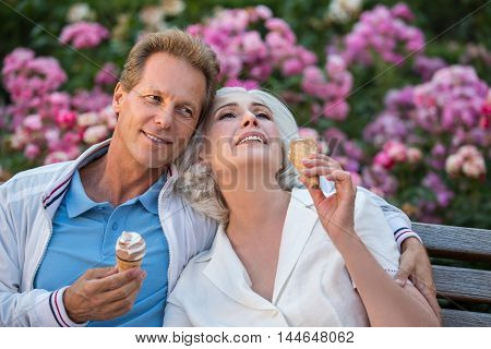 Man smiles and hugs woman. Couple with ice cream. Let's have a rest together. Every moment is priceless.