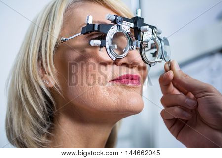 Optometrist examining female patient with messbrille in ophthalmology clinic