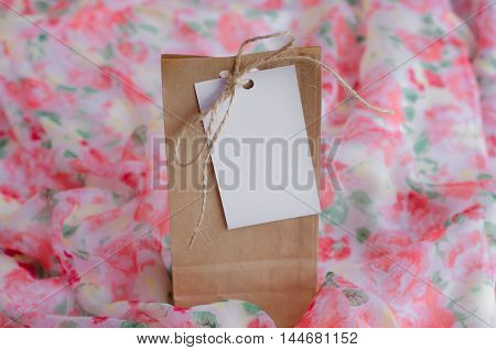 Gift bag with white tag on a beautiful background