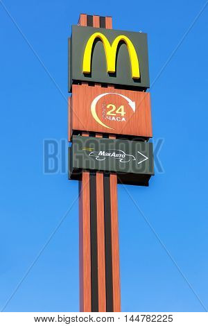 TVER REGION, RUSSIA - JUNE 26 2016: McDonald's logo on a pole against the blue sky. McDonald's is the world's largest chain of hamburger fast food restaurants