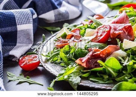 Dried beef bresaola. Salad bresaola arugula baby spinach tomatoes lime and cheese parmesan.