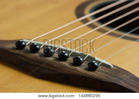 Still life photo by acoustic guitar bridge pins and saddle