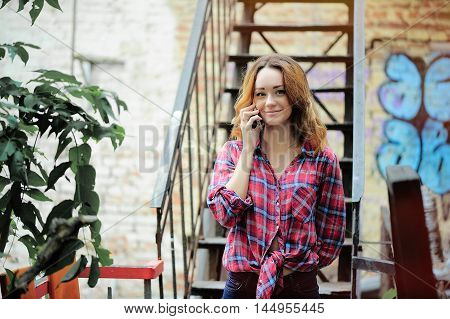 bright girl in a plaid shirt talking on the phone the youth of today