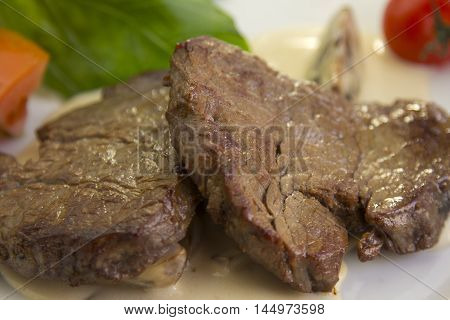 meat in sauce with potatoes and vegetables on a white background