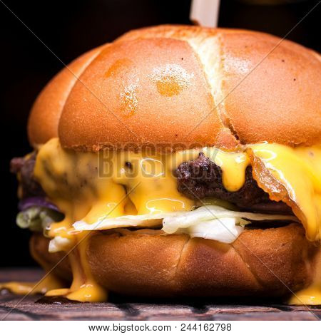 Burger with melted cheese for football fans. Big cheeseburger with melted cheese 