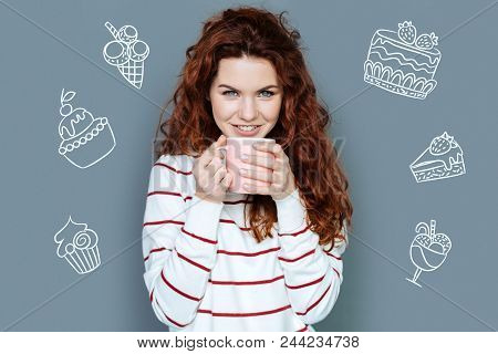 Delicious Drink. Cheerful Pretty Young Woman Feeling Good While Sitting With A Big Cup And Enjoying 