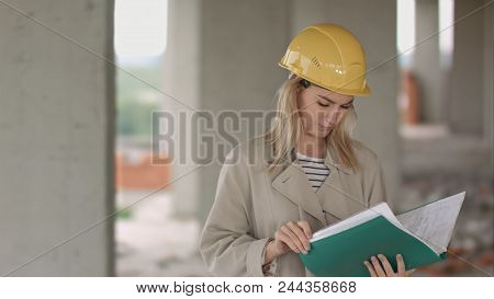 Young Female Architect Construction Engineer At A Construction Site Eximaining