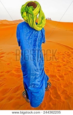 Young Camel Driver Wearing Blue Dress In Moroccan Desert