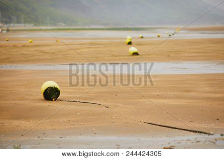 Buoys On Beach Of Villers-sur-mer In Lower Normandy, France On A Foggy Day At Low Tide