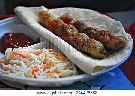 Portion Of Lula-kebab On Wheat Pita With Ketchup And Salad