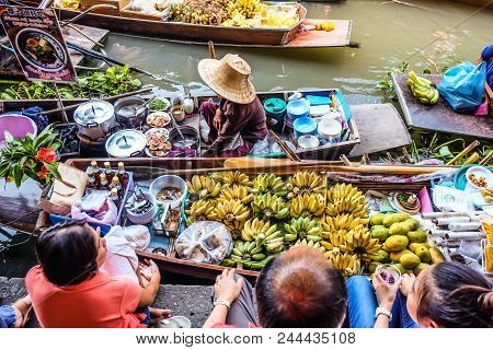 BANGKOK – MARCH 18: People shopping food from wooden boats at Amphawa floating market on March 18, 2