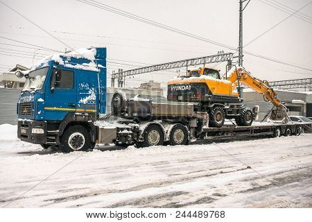 Moscow, Russia - February 05, 2018: Specialised Powerful Lorry Transports Yellow Wheel Excavator Hyu