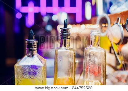 Syrup In Glass Bottles. Various Flavors Of Food Syrups In Bottles