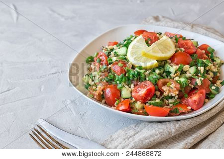 Tabbouleh (tabouli) Salad On A Dish On Light Gray Concrete Background. Healthy Vegetarian Food. Leba