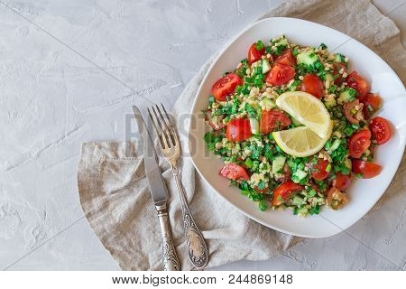 Tabbouleh (tabouli) Salad On A Dish On Light Gray Concrete Background. Healthy Vegetarian Food. Leba