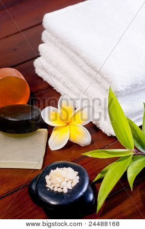 Concetto di Spa con Zen Stone, sale da bagno, sapone e un fiore giallo