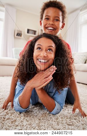 Portrait Of Son Lying On Mothers Back In Lounge
