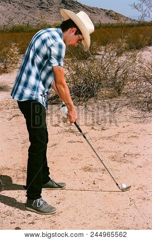 Young Boy In Natural Terrain Desert Golfing