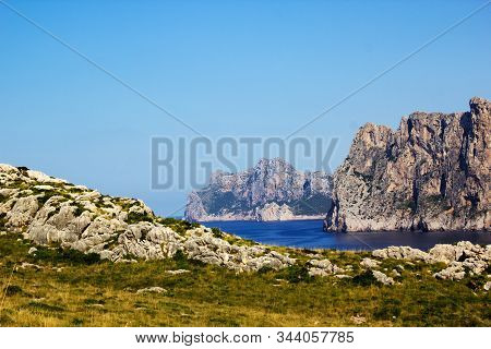 View Of Mountains And Beautiful Blue Sea With Stones And Grass In Foreground At The Pointview In The