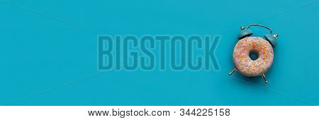 Banner 3:1. Pink Alarm Clock Donut On Blue Background. Breakfast Time Or Minimal Concept. Copy Space