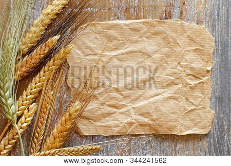 Grain Spikes And Craft Paper On A Wooden Table