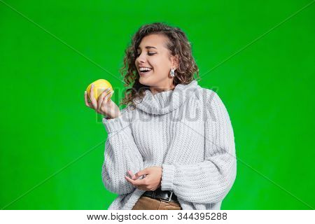 Organic Food Concept. Smiling Female Looking At A Yellow Apple With Temptation And Geat Desire To Bi