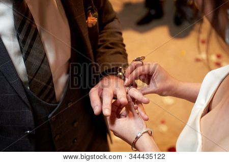 Bride Dresses The Ring For The Groom, Close-up In Marriage Registry Office