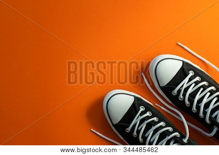 Top View New Black Fashion Shoe With White Rope On Orange Paper Background