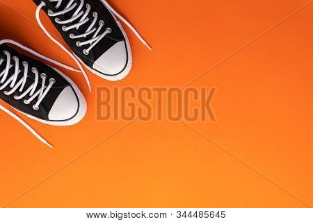 Top View New Black Fashion Shoe With White Rope On Orange Paper Background