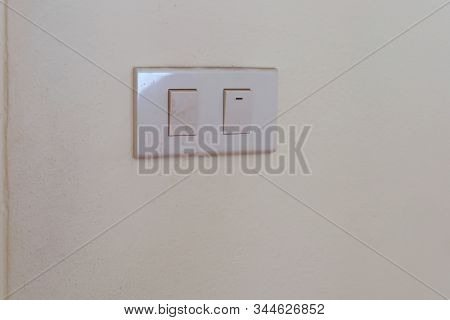 White Electrical Switch Plate On The Wall For Control The Light Turning On Or Off.