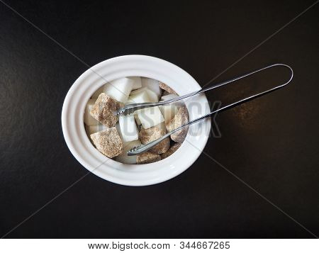 Sugar-basin With Cubes Of White And Brown Sugar On Black Background
