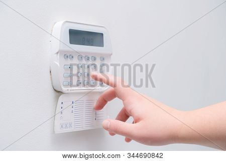 Woman Hand Entering Alarm System Password Of An Apartment, House Of Business Office. Surveillance An