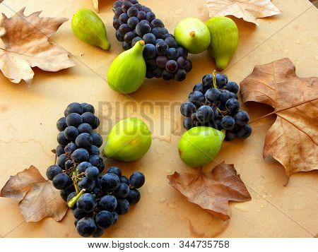 Bunch Of Grapes And Figs On A Wooden Table
