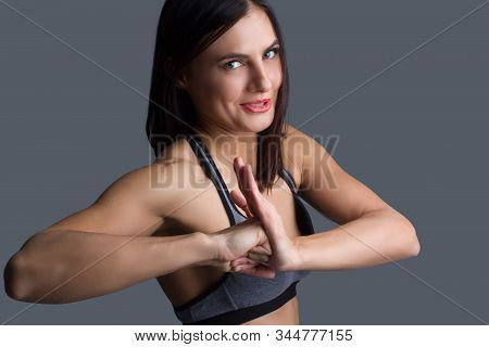 Girl In Gray Sweatpants And Top. Makes A Fist To Palm Gesture With His Hands