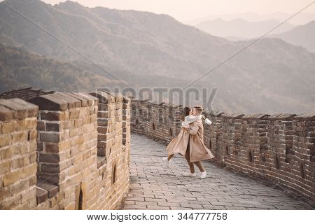 Young Couple Running And Twirling At The Great Wall Of China